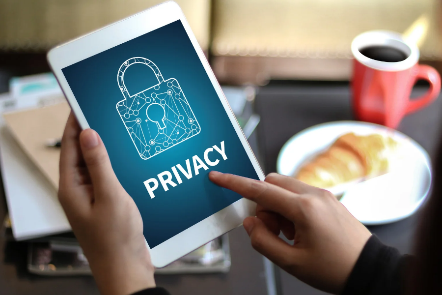 Person holding a tablet with a privacy lock symbol, illustrating the privacy policy
